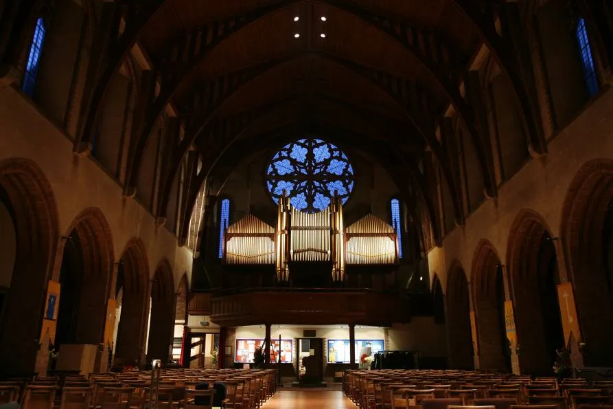 The organ in the west gallery of St Barnabas, its gilded pipes standing beneath the rose window