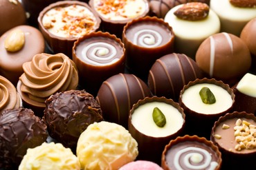 Assorted chocolate truffles and pralines arranged closely together