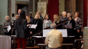 The Ealing Gospel Choir singing together, accompanied by piano