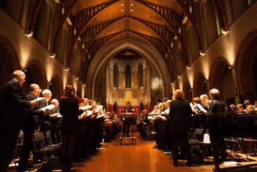 Choir and clergy singing in the candlelit church nave during a service