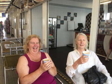 Two women enjoying ice creams at a seafront café in Brighton