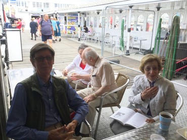 A group from Pop-In sitting together at a seafront café table