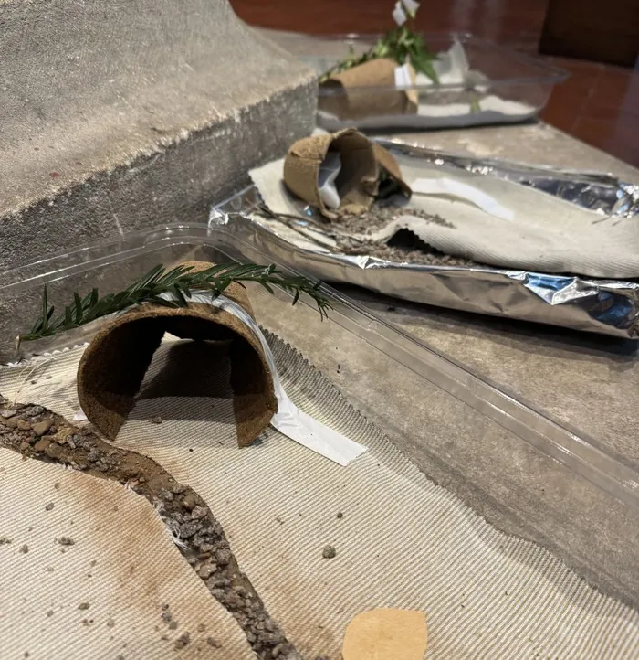 Small paper tombs decorated with rosemary sprigs, made in a children's workshop