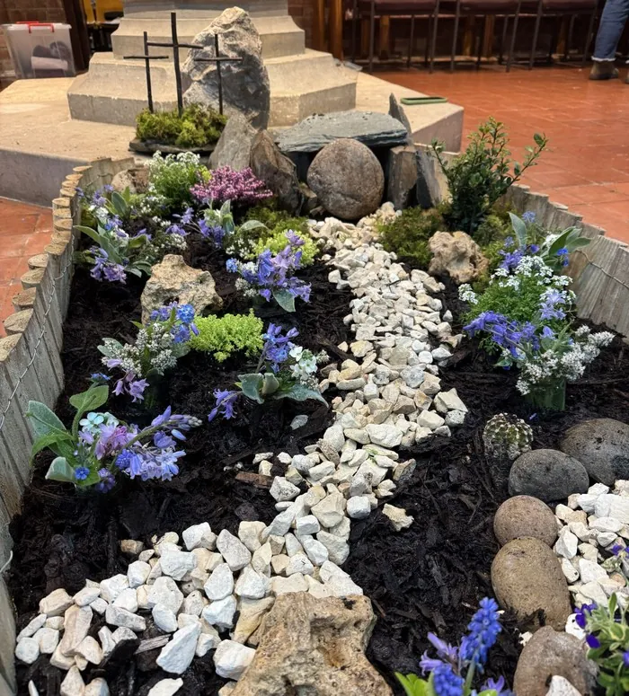 An Easter Garden of flowers, moss and stones with three small crosses