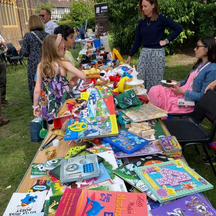 Children and adults browsing a toy stall at the Summer Fayre