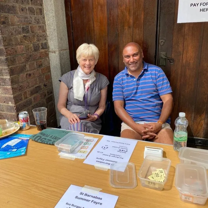 Two volunteers seated at the food stall payment table