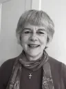 Felicity smiling, wearing a patterned scarf and a small cross, in a black-and-white photograph